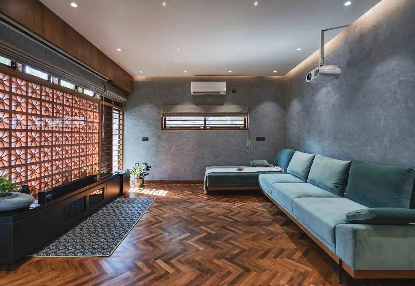 A stylish living room with polished wooden floors and a plush couch, featuring a modern setup ideal for the best home theater installation in Kerala.